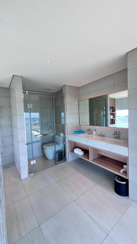 a bathroom with two sinks and a tub and a toilet at Executive Bay View A La Carte Hạ Long in Ha Long
