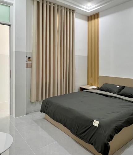 a bedroom with a large bed and curtains at Ancor Homestay in Phan Rang–Tháp Chàm