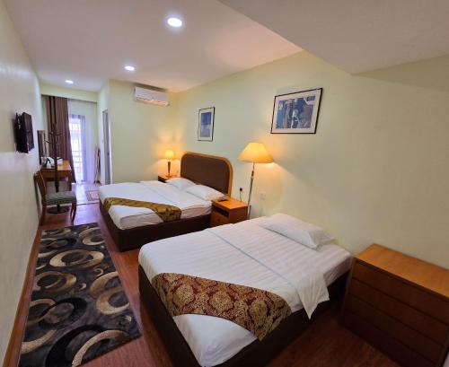 a hotel room with two beds in a room at Grand Luxury Hotel Semporna in Semporna