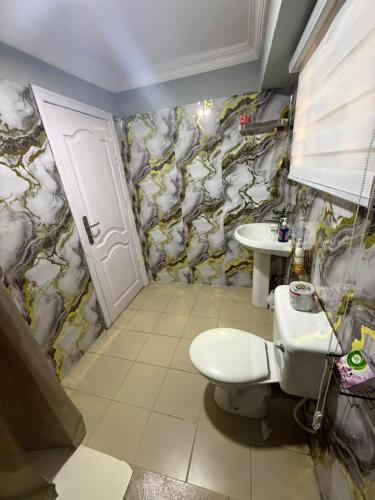ein Badezimmer mit Toilette und Waschbecken in der Unterkunft Royal Max in Ikeja