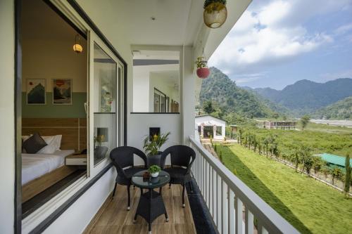 a balcony with a bed and a table and chairs at PACK Rishikesh, Mohanchatti in Rishīkesh