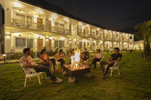 a group of people sitting around a fire in front of a building at PACK Rishikesh, Mohanchatti in Rishīkesh