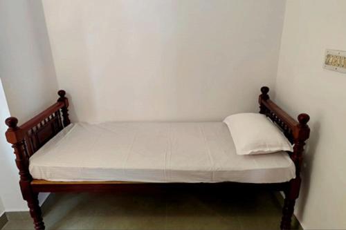 a small bed in a corner of a room at Agapi Homestay in Cochin