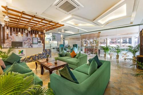 a lobby with green couches and a table at Treebo Premium Landmark Prayagraj in Prayagraj