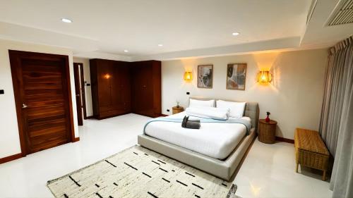 a bedroom with a large white bed and a door at Mali Villa 57 in Patong Beach
