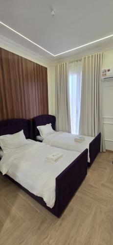 a hotel room with two beds and a window at Dar Alslam hostel in Nizwa