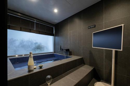 a bathroom with a tub with a flat screen tv at Hotel Jak Insadong by Anook in Seoul