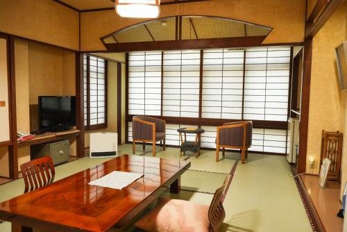 a dining room with a wooden table and chairs at New Ogiya in Fukushima