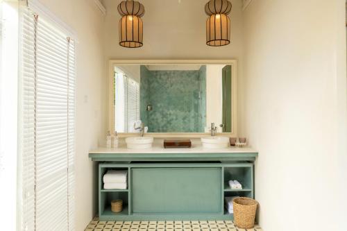 a bathroom with two sinks and a mirror at Jungle Beach an Uga Experience - Trincomalee in Trincomalee