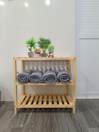 a wooden shelf with towels and plants on it at Motel NHÀ SAM in áº¤p VÄ©nh ÃÃ´ng