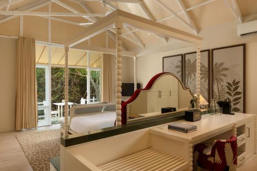 a bedroom with a bed and a mirror at Jungle Beach an Uga Experience - Trincomalee in Trincomalee