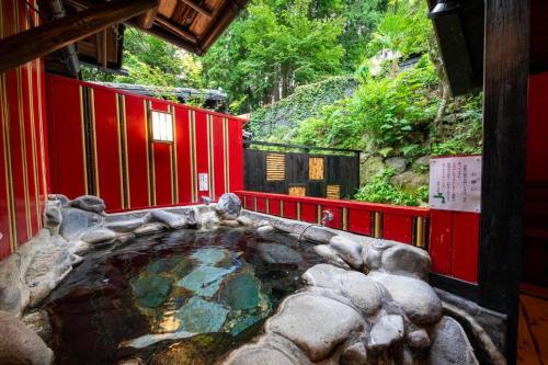 a hot tub in the middle of a building at Bessou Konjakuan in Yufu