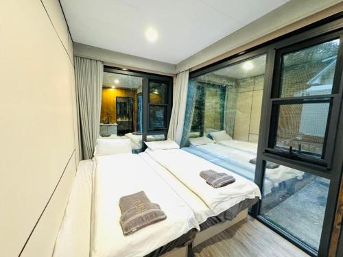 a room with two beds and a large window at 箱根コンテナステイ 富士山を望む徒歩3分 海賊船で芦ノ湖観光 in Hakone