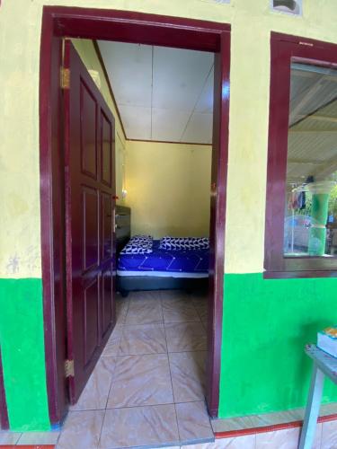 an open door to a room with a bed in it at Hatiku Guesthouse in Bunaken