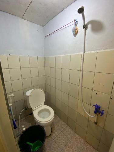 a bathroom with a toilet and a shower at Hatiku Guesthouse in Bunaken