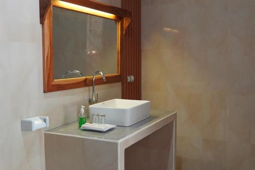 a bathroom with a white sink and a mirror at Salili Resort in Gili Islands