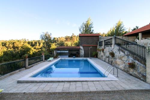 a swimming pool on a patio with a house at Casa Rural Da Costeira in Cinfães