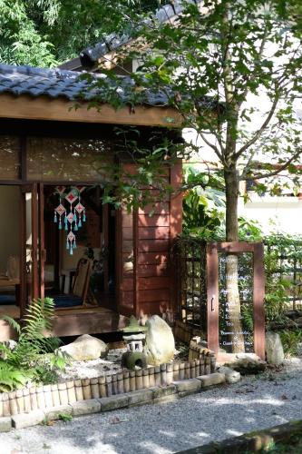 a small cabin with a chair and a tree at Baannai Homestay & Flower Tea in Ban San Na Meng
