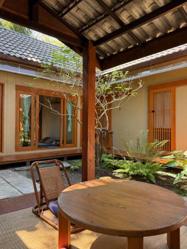 a patio with a wooden table and a table and chairs at Baannai Homestay & Flower Tea in Ban San Na Meng