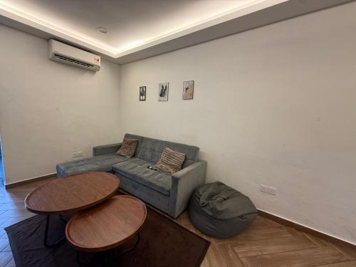 a living room with a couch and two tables at Ujang Guest House in Batu Kikir
