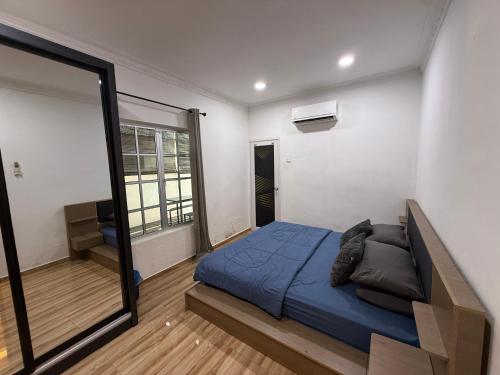 a bedroom with a bed and a large mirror at Ujang Guest House in Batu Kikir