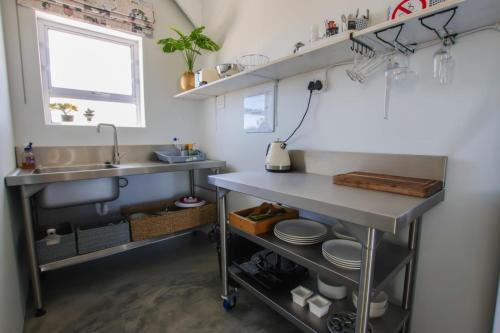 a small kitchen with a sink and a counter at At3Brides Self Catering in St. Helena Bay