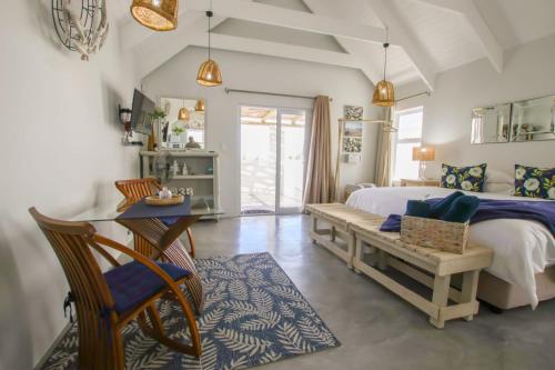 a bedroom with a bed and a table and chairs at At3Brides Self Catering in St. Helena Bay
