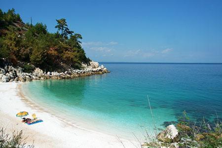 a group of people laying on a beach at Oneiro Zois villas in Prinos
