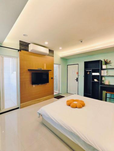 a bedroom with a large white bed with orange pillows on it at Kinmen Harved B&B in Jinhu