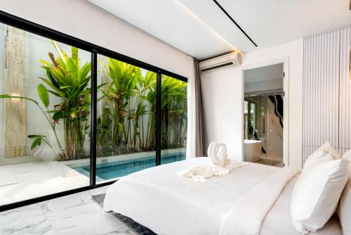 a bedroom with a white bed and a pool at Anoya Boutique Villa in Kerobokan
