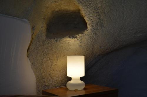 a white lamp sitting on a table next to a wall at Locus Amoenus in Matera