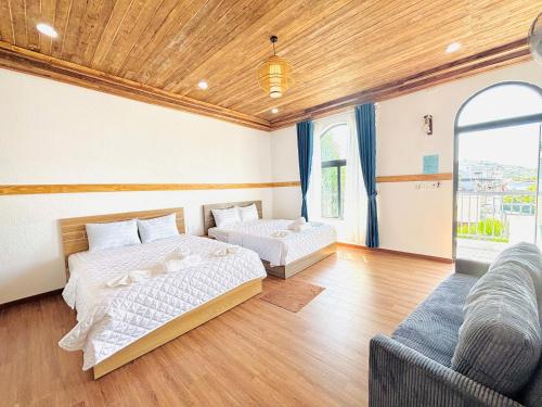 a bedroom with two beds and a couch at Homestay Mr Hồng Vĩnh Hy in Ninh Hải