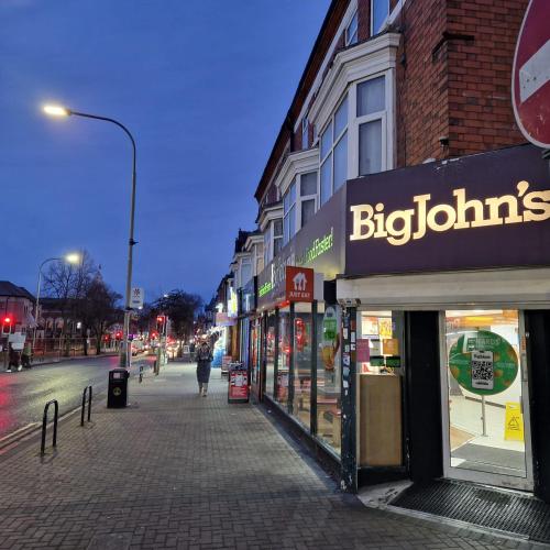 a person walking down a street in front of stores at 4 Norman House Leicester in Leicester