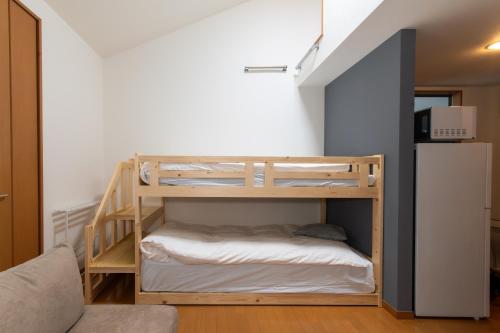 a bunk bed in a room with a refrigerator at Suncity Hakata in Hakata