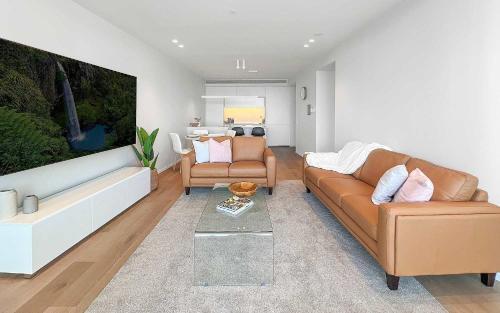 a living room with a couch and two chairs at Marina Vista - Waterfront Apartment in Shellharbour
