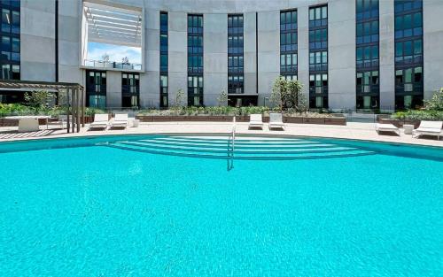 a large swimming pool in front of a building at Marina Vista - Waterfront Apartment in Shellharbour