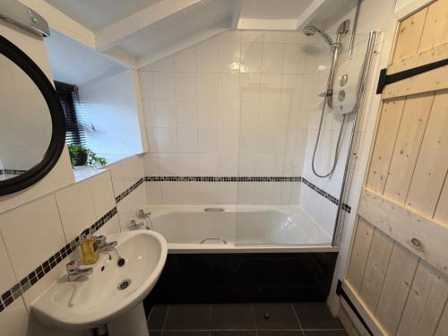 a bathroom with a sink and a bath tub at Byre Cottages & Log Cabin in Cardigan