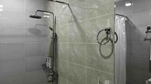a shower with a glass door in a bathroom at Chinor Hotel Fergana in Fergana