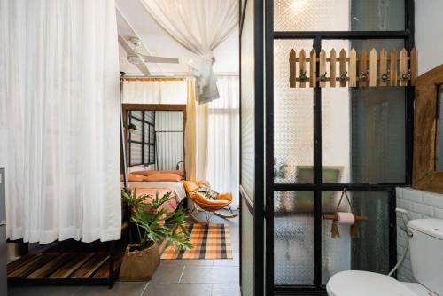 a bathroom with a toilet and a bedroom at StayX Central Suites Q1 in Ho Chi Minh City