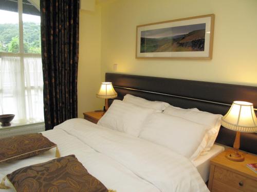 a bedroom with a large white bed with two lamps at Croft Mill in Hebden Bridge