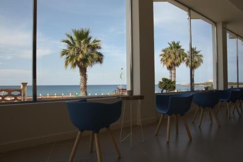a dining room table with chairs and umbrellas at Hotel Vittorio in Portopalo