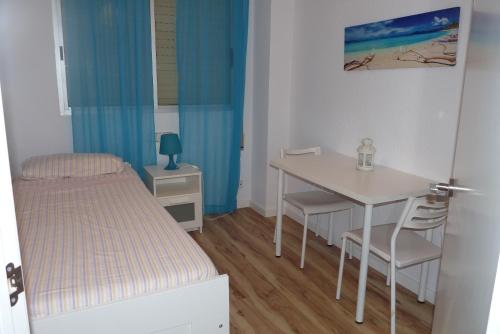 バレンシアにあるApartment Savoyの小さなベッドルーム(ベッド1台、テーブル、椅子付)