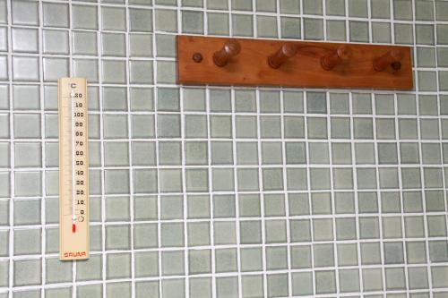 a ruler and a thermometer on a tiled wall at Hotel Jardim in Jardim