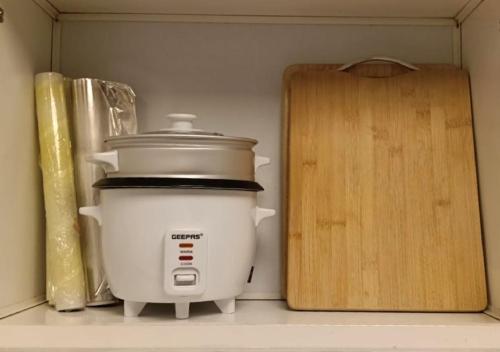 a slow cooker and a cutting board in a kitchen at Lake View 1BR Apt Balcony & Near DMCC Metro in Dubai