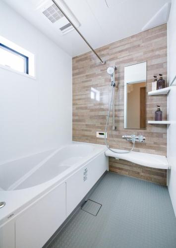 a bathroom with a tub and a mirror at ぷふか東向島 in Tokyo