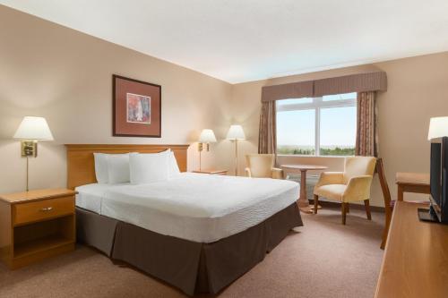 Rúm í herbergi á Days Inn by Wyndham Oromocto Conference Centre