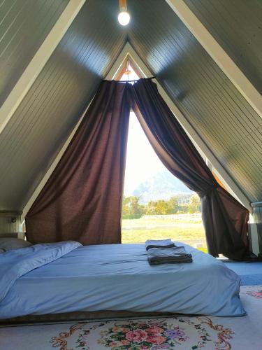 a tent with a bed with a window in it at Western View Chiangdao Camping in Chiang Dao