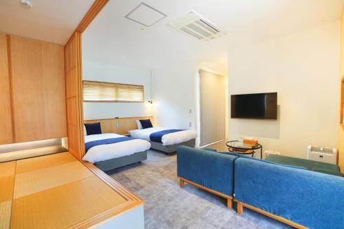 a hotel room with two beds and a couch at Bise SMC Village in Motobu