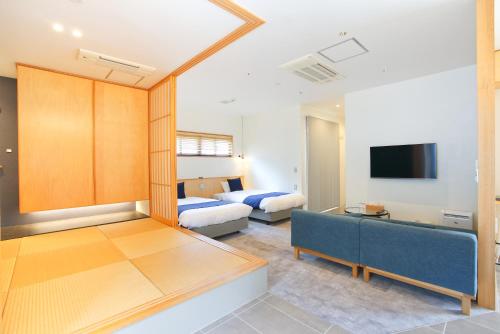 a living room with a couch and a bed and a tv at Bise SMC Village in Motobu