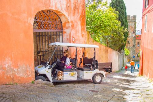 a golf cart with two people and a dog in it at Hotel Villa Sermolli in Borgo a Buggiano